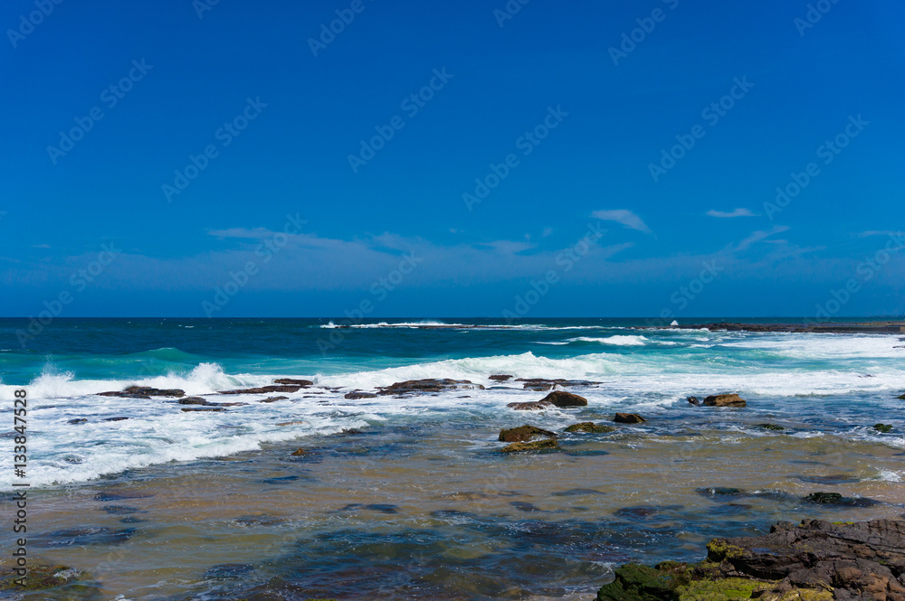 Blue ocean surface and clear sky. Summertime vacation background