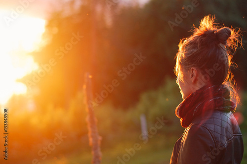 Принти на полотні Young woman looking at glowing sunset flare
