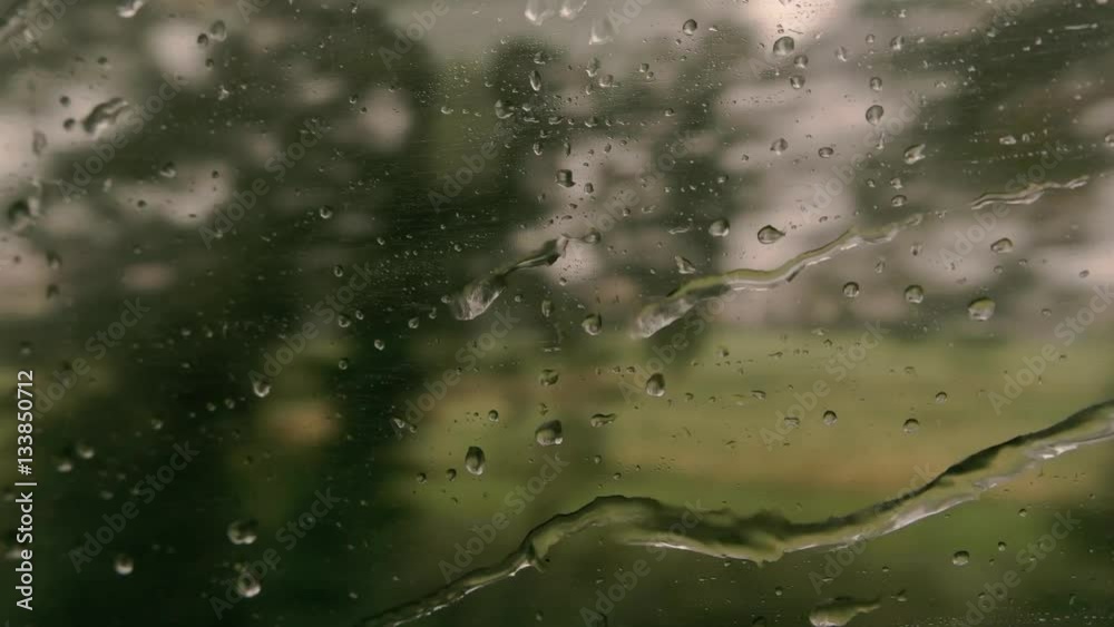 Train window with water droplets. Blurred landscape and sky. Further and further from home. Train window with water droplets. Blurred landscape and sky. Further and further from home.