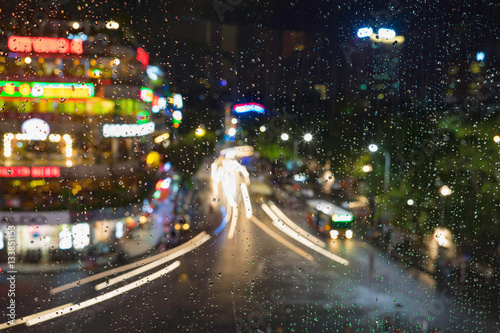 Rain water drops on a window glass after the rain with cityscape and street view on background
