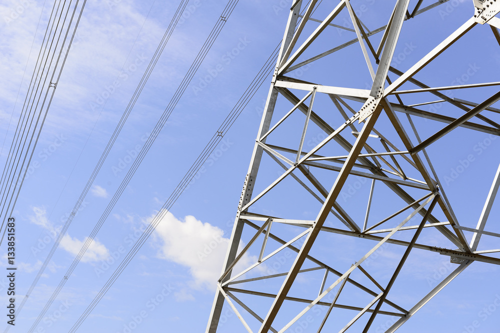 Closeup of the base structure of electricity pylon with the blue sky