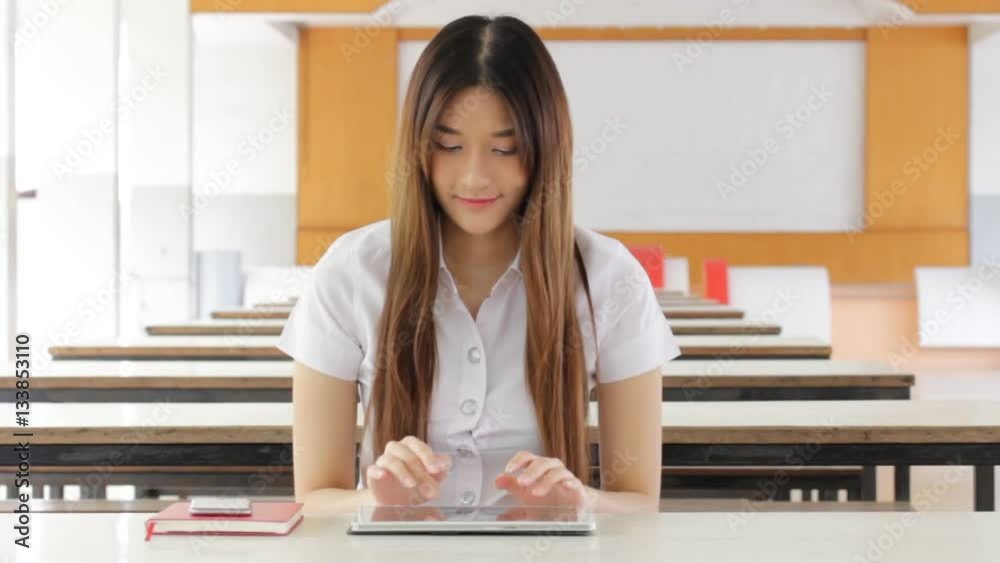 Portrait of thai adult student university uniform beautiful girl using her tablet. Portrait of thai adult student university uniform beautiful girl using her tablet.