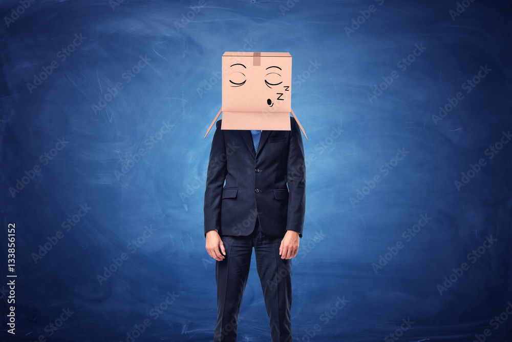 Businessman is wearing cardboard box on head with sleepy face Businessman is wearing cardboard box on head with sleepy face