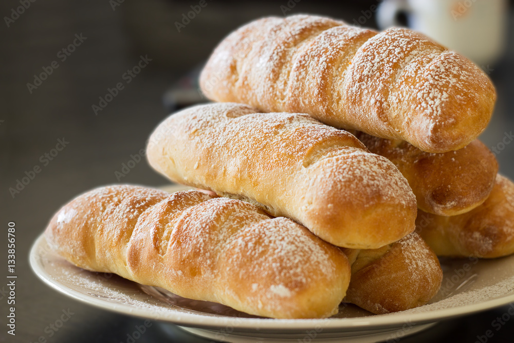 Homemade sweet buns with vanilla custard cream filling on plate. Selective focus, blur background Homemade sweet buns with vanilla custard cream filling on plate. Selective focus, blur background