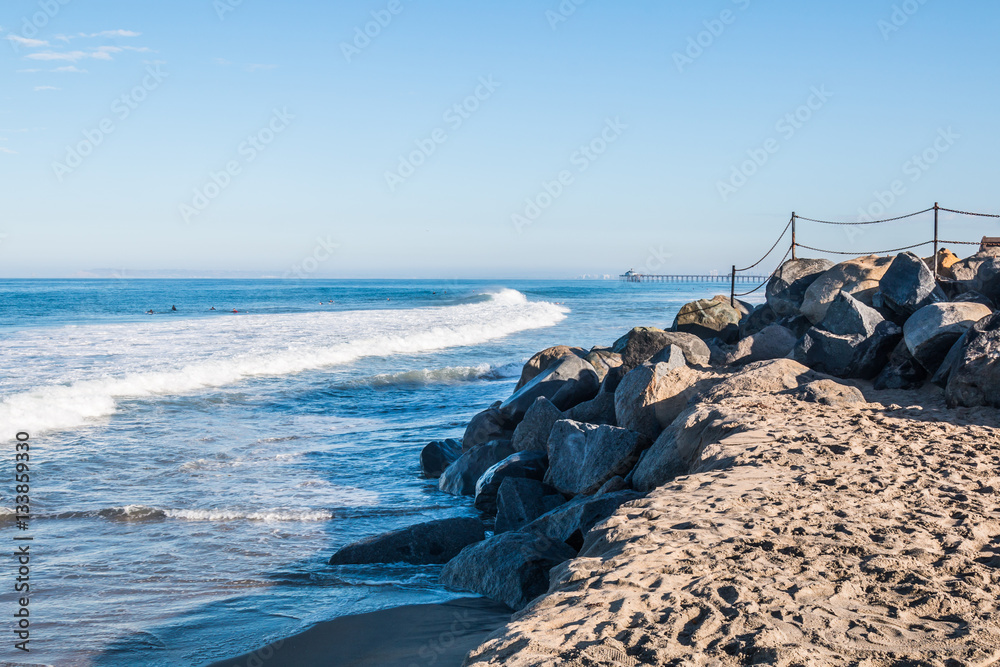 Rocky landscape with Imperial Beach fishing pier in the background.