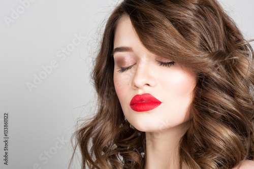 Studio portrait of a beautiful young woman. Fashion Makeup Model with perfect makeup  red lips and smooth  clean skin