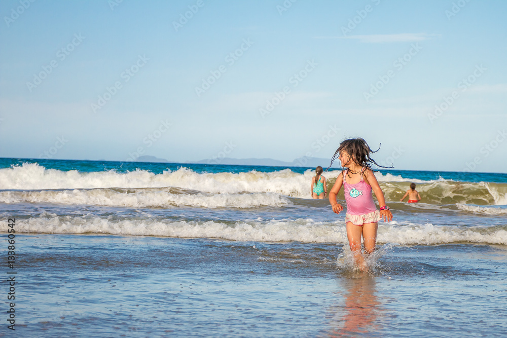 young happy child girl having fun on sand beach, sea background young happy child girl having fun on sand beach, sea background