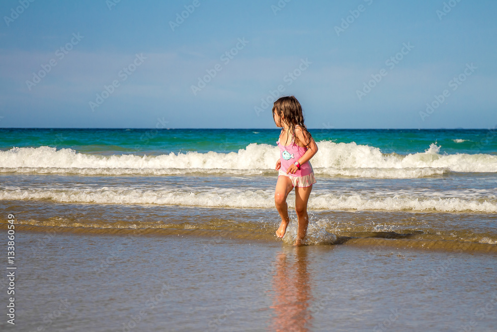 young happy child girl having fun on sand beach, sea background young happy child girl having fun on sand beach, sea background