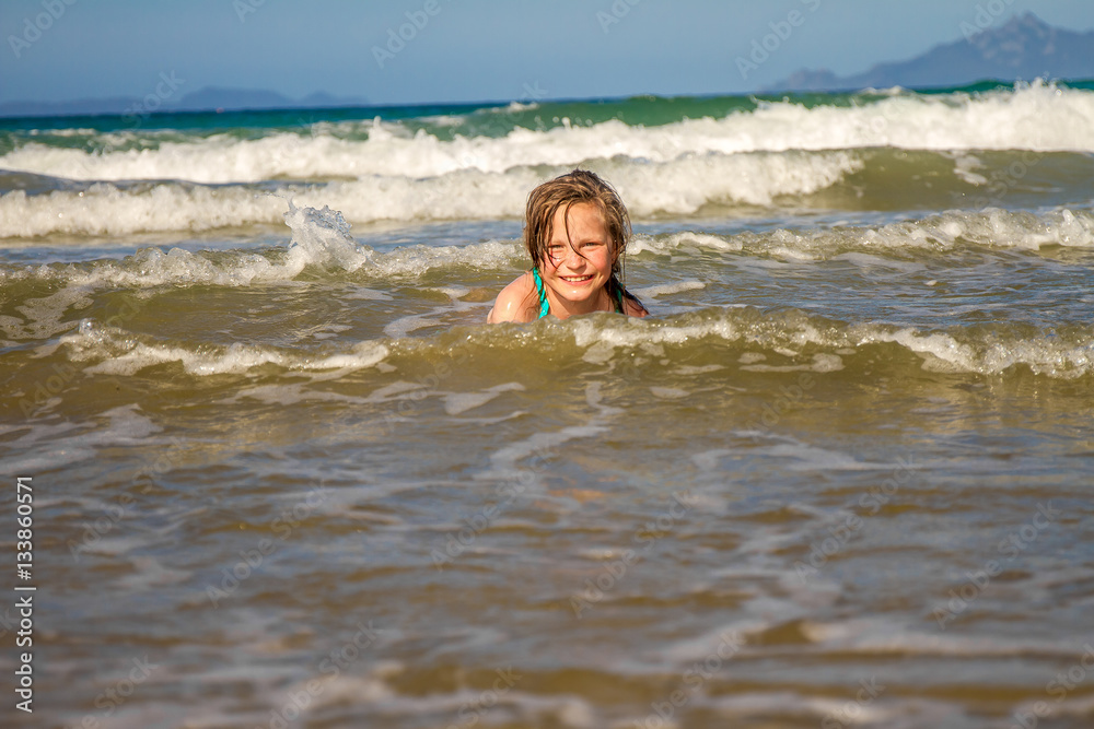 young happy child girl having fun on sand beach, sea background young happy child girl having fun on sand beach, sea background
