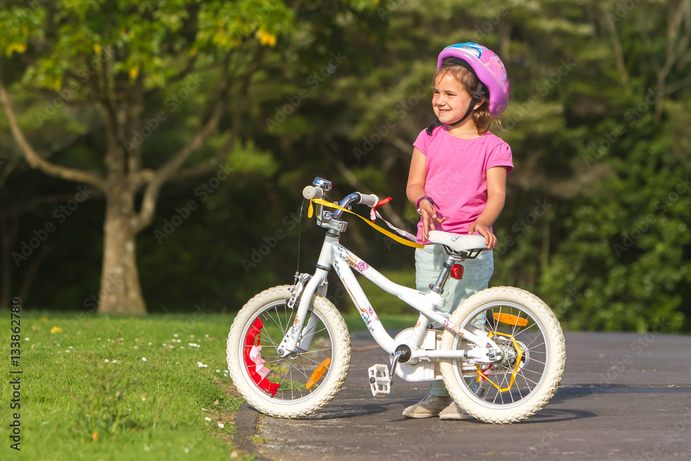 outdoor portrait of young happy child girl riding a bike in park outdoor portrait of young happy child girl riding a bike in park