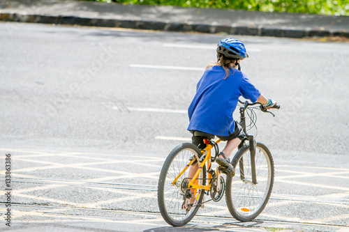 young happy preteen child boy riding a bicycle on urban backgrou