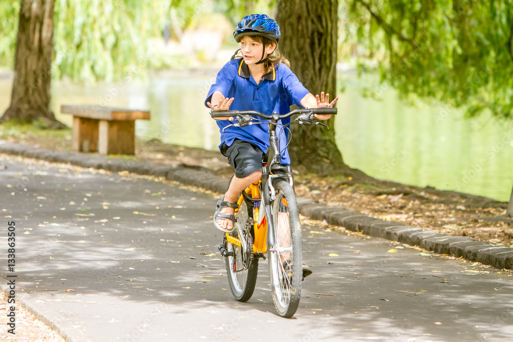 Fototapeta premium young happy preteen child boy riding a bicycle on natural park b