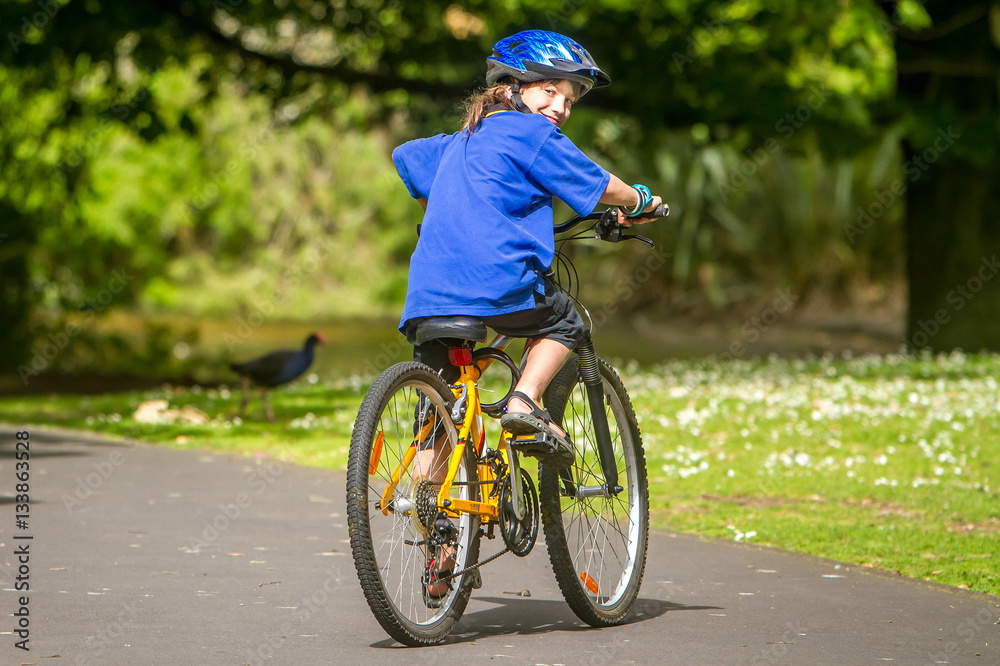 young happy preteen child boy riding a bicycle on natural park b