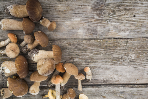 Foto Raw mushrooms on a wooden table. Boletus edulis and chanterelles