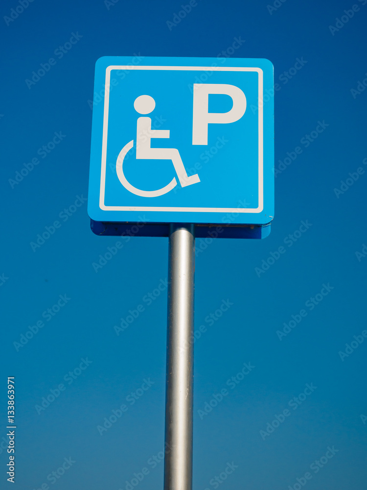 Disabled parking space and wheelchair way sign and symbols on a pole warning motorists Disabled parking space and wheelchair way sign and symbols on a pole warning motorists