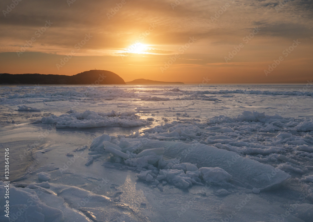 Frozen sea at sunset. Selective focus on foreground.