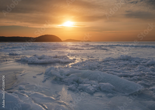 Frozen sea at sunset. Selective focus on foreground.