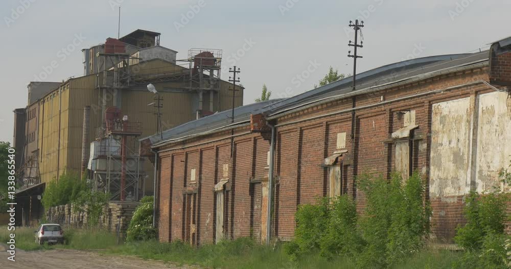 Car Parked Near Entrance of Cement Factory Building of the Plant Pipes Among Green Trees and High Grass Cloudy Sky Dull Industrial Landscape Sunny Evening Car Parked Near Entrance of Cement Factory Building of the Plant Pipes Among Green Trees and High Grass Cloudy Sky Dull Industrial Landscape Sunny Evening