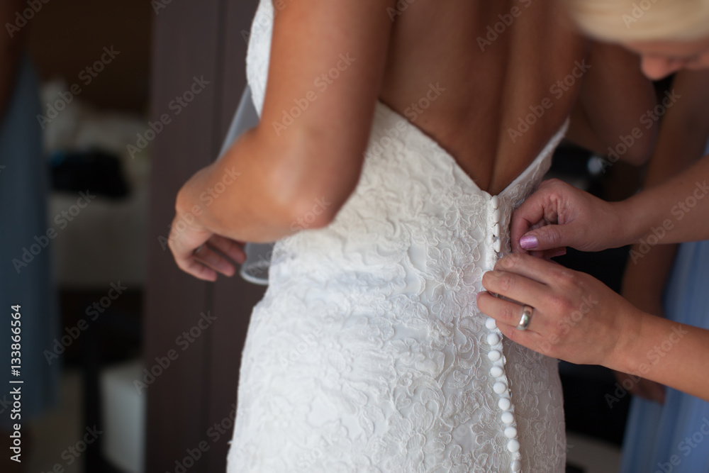 Obraz premium Mom helps dress bride wedding dress from a back
