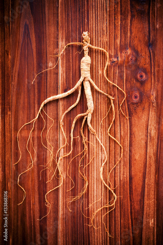Dry ginseng on a wood background (Concept of traditional Chinese medicine)
