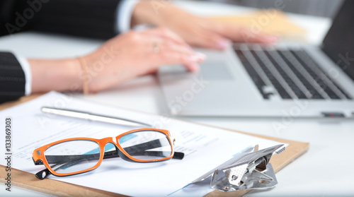 Woman working on laptop, sitting at the desk