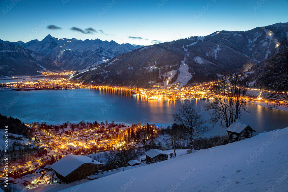 Fototapeta premium View over Zell am See mountain village at night in winter, Salzb