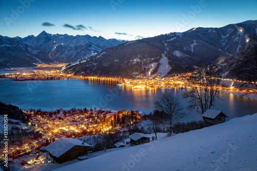 View over Zell am See mountain village at night in winter, Salzb