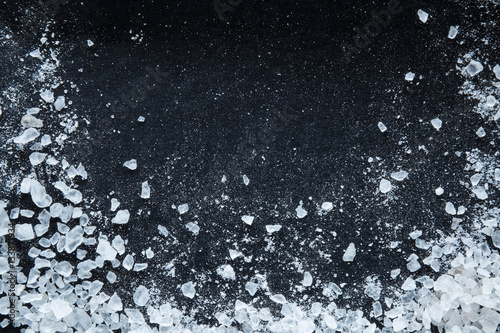 Sea salt grains on the black background.