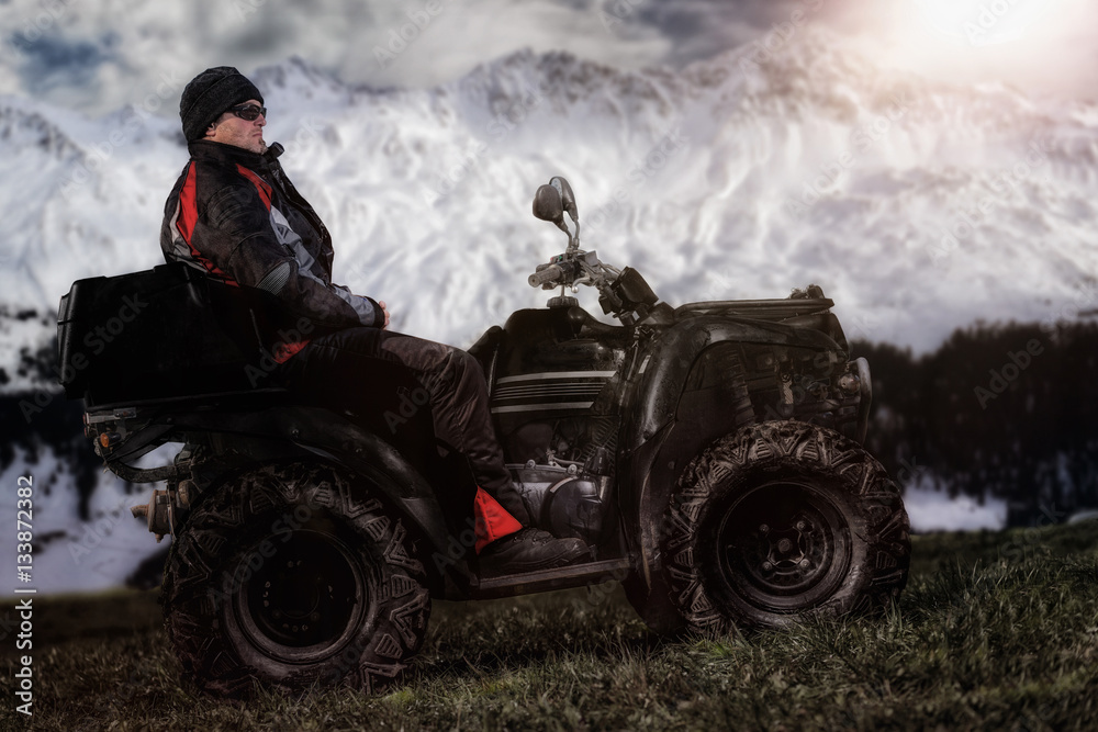 Fototapeta premium Mann sitzt auf ATV / Quad und wartet