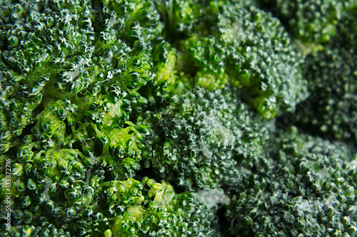 Wet fresh green broccoli with water drops closeup as background. Healthy vitamin food.