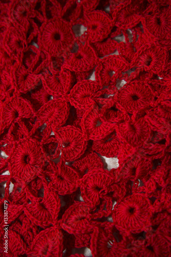 Red cardigan knitted in manual photographed in close-up.