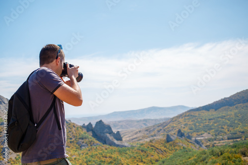 Man photographing mountain in summer