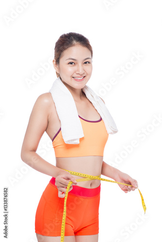 Portrait of fitness young asian woman with towel holding measuring tape © makistock
