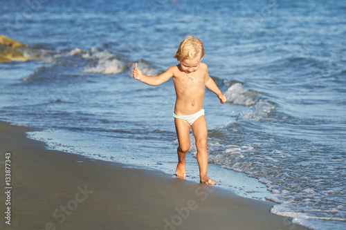 Young baby running at the sea shore