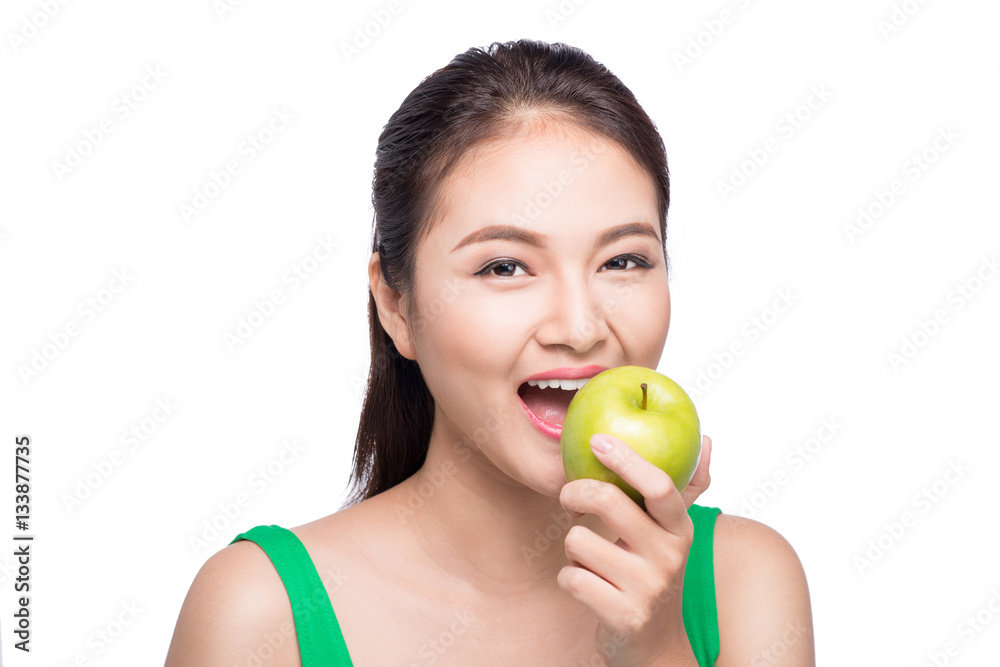 Attractive smiling young asian woman eating green apple isolated Attractive smiling young asian woman eating green apple isolated