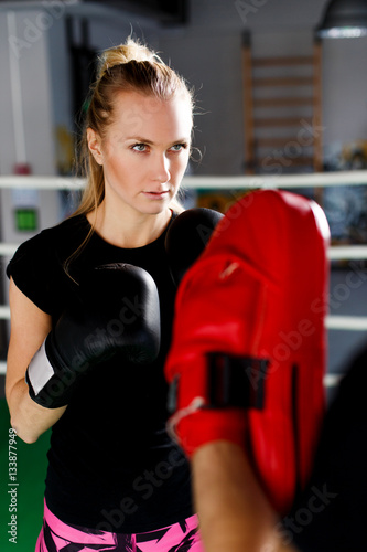 Blonde engaged boxing with trainer