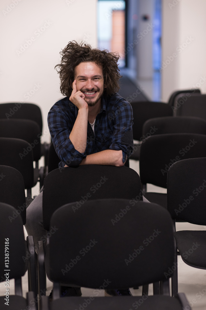 A student sits alone  in a classroom