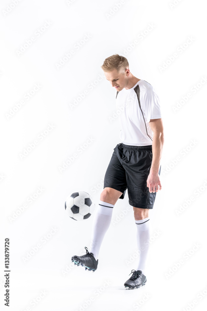 Soccer player exercising with ball
