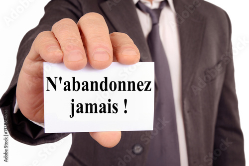Photos Homme tenant une carte avec n'abandonnez jamais écrit dessus