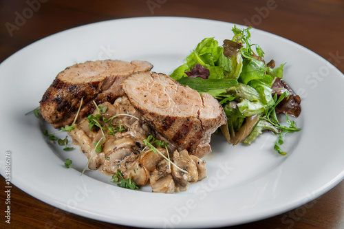 Fillet of pork grilled with mushrooms and cream soum. Dish lies