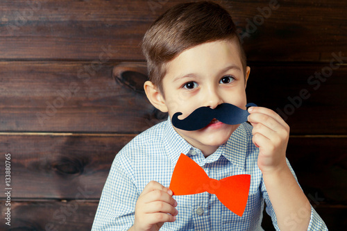 A kid with props for a photo booth. The child with the requisite photo