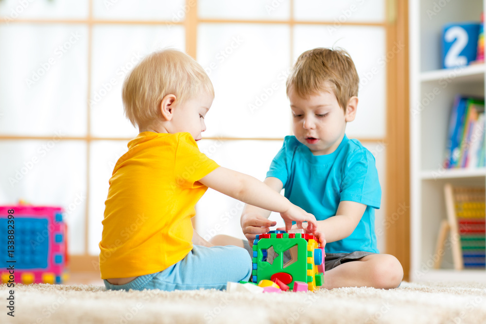 Kids toddler preschooler boys playing logical toy learning shapes and colors at home or nursery Kids toddler preschooler boys playing logical toy learning shapes and colors at home or nursery