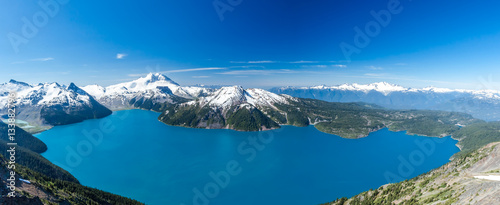 Panoramic wide scenery from Panorama Ridge peak with view over whole Garibaldi lake and surrounding mountains covered in snow during sunny summer day, Whistler, British Columbia, Canada. © Lubomir