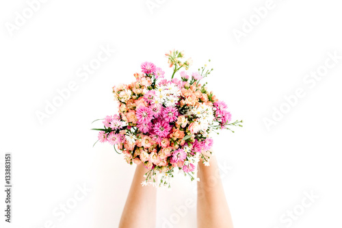 Girl s hands holding wildflowers bouquet on white background. Flat lay  top view