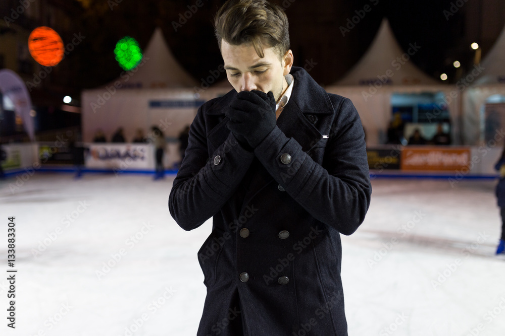 Handsome young man ice skating on rink outdoors. Handsome young man ice skating on rink outdoors.