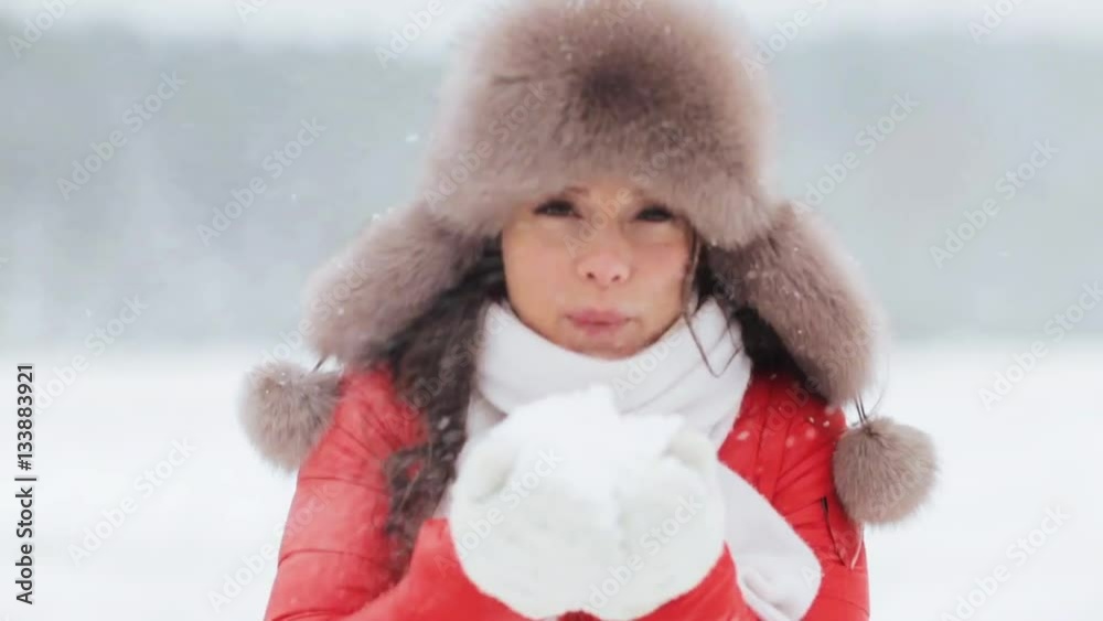 happy woman playing with snow outdoors in winter