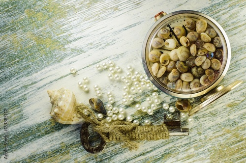 Scattered pearls and converted clock with seashells and old key.