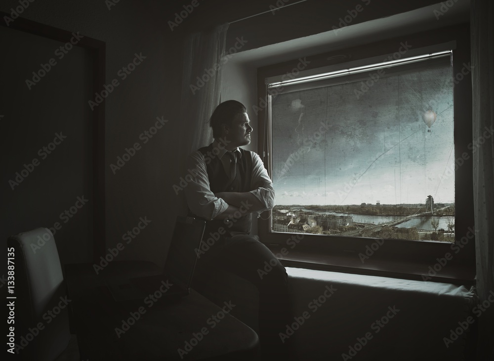 Businessman Looking Out of Window in His Office and Thinking About New Business Plans