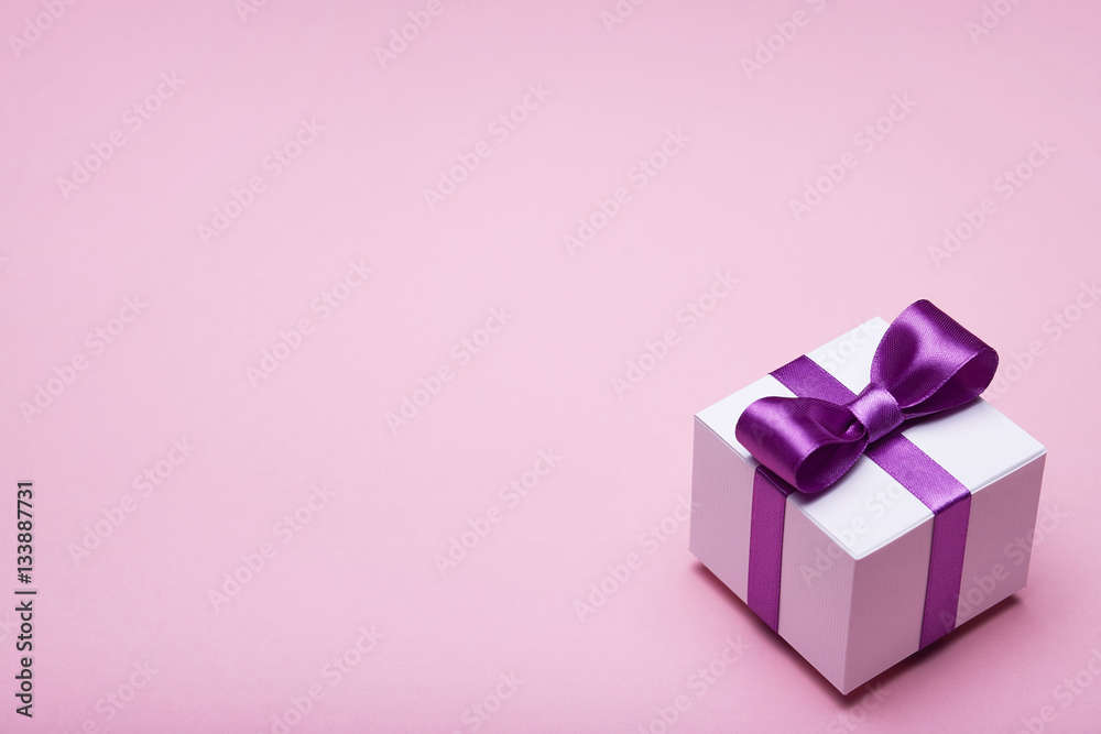 Box with a gift on pink background