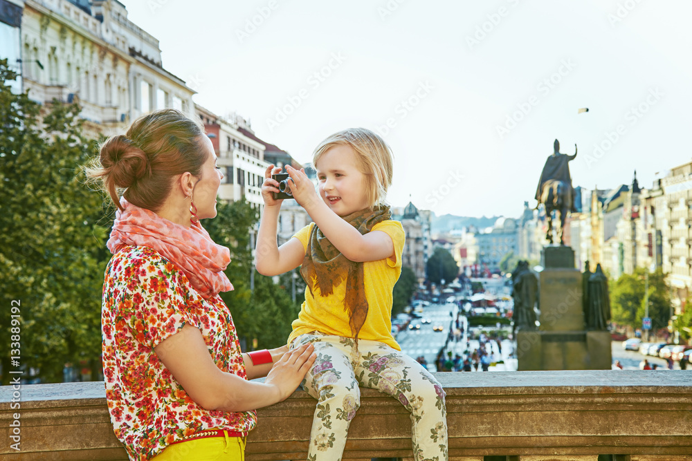 Obraz premium mother and child with digital camera taking photo in Prague